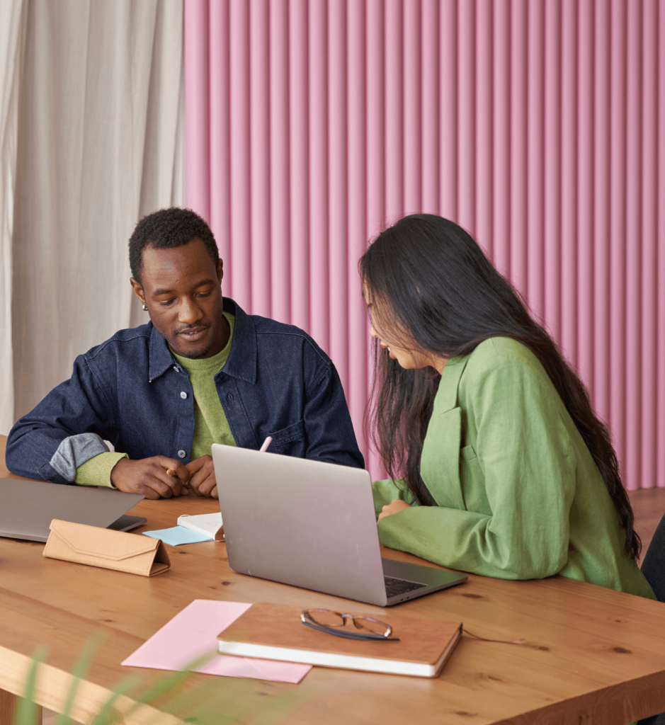 Dos personas haciendo networking frente a una laptop.